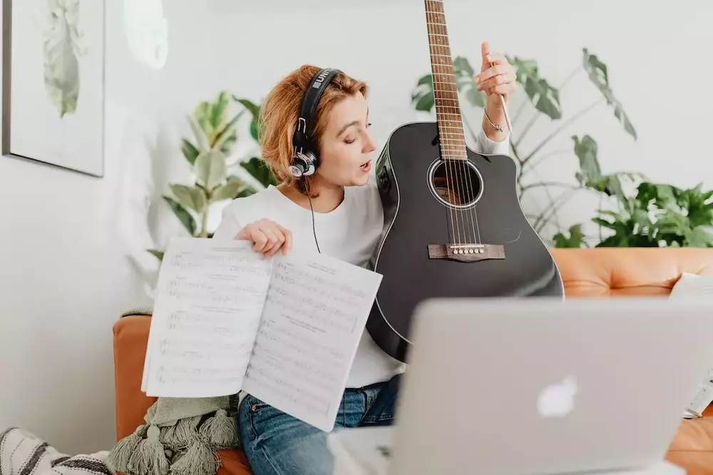 chica enseñando clases de guitarra por Internet